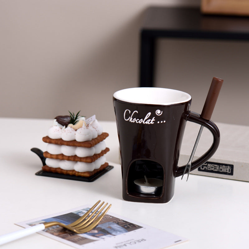 Chocolate brown Fonduette mini fondue mug with its fork, next to a dessert