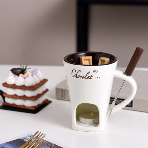 White Fonduette mini fondue mug with its fork, next to a dessert