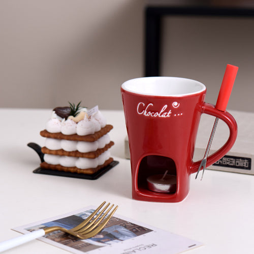 Red Fonduette mini fondue mug with its fork, next to a dessert